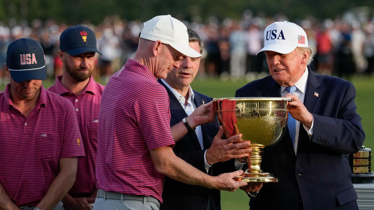 Donald Trump hands the trophy to USA team captain Brandt Snedeker.